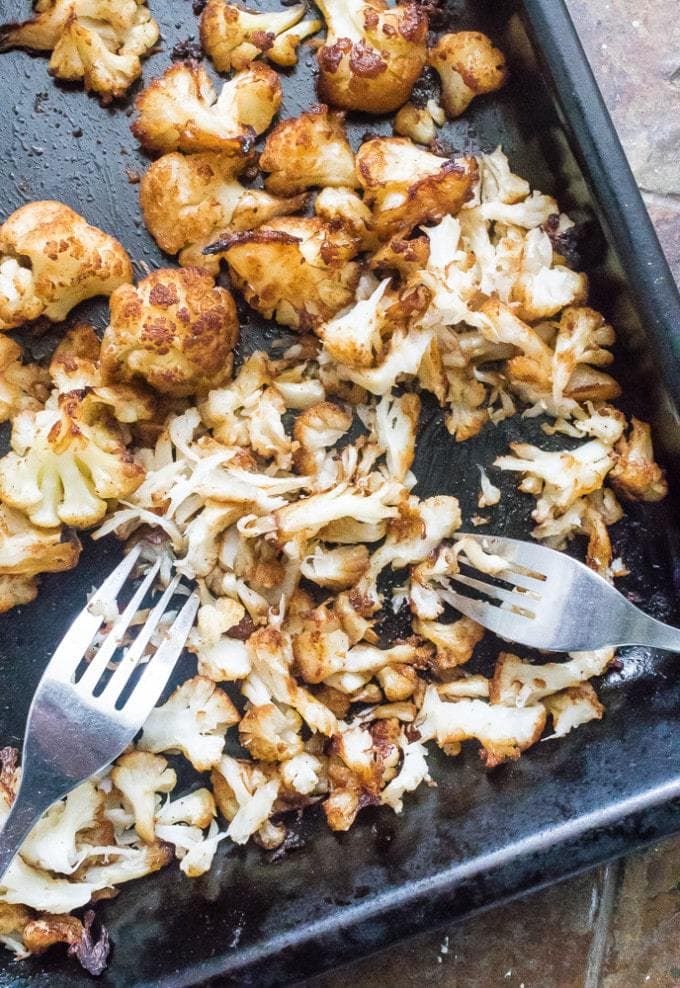 Roasted cauliflower being shredded with forks.
