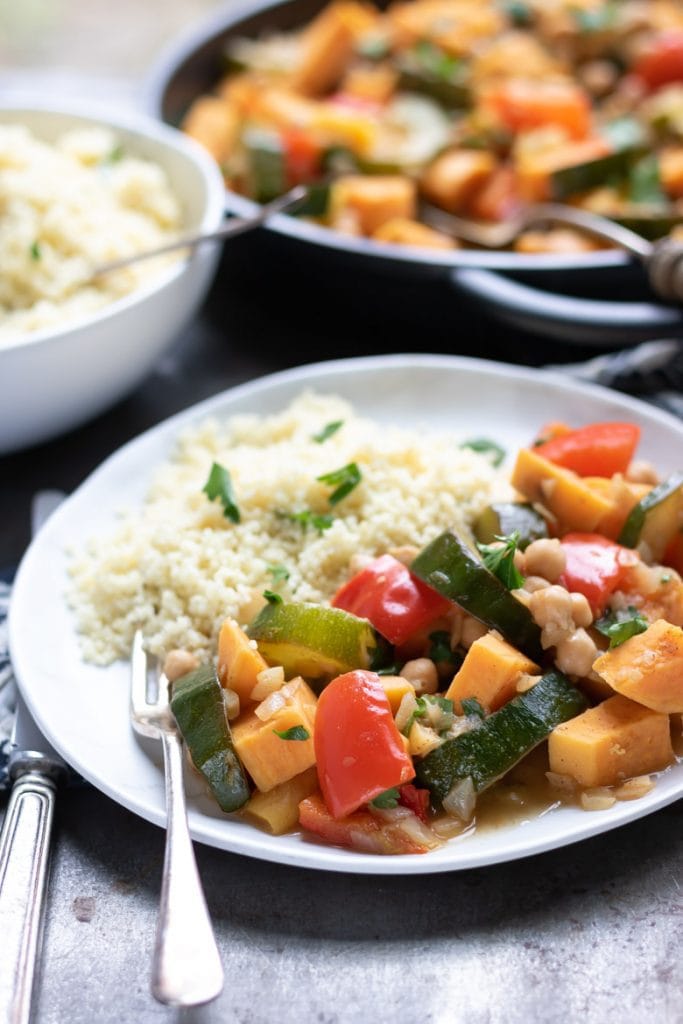 Close up of a plate of Moroccan Vegetable Tagine with couscous and a fork.