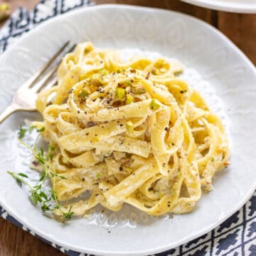 Plate of pasta topped with pistachios.