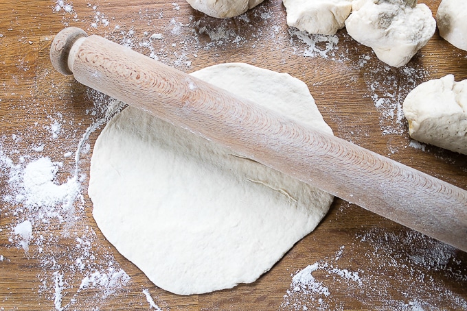Dough being rolled out with a rolling pin.