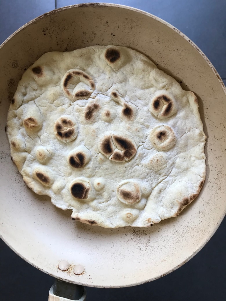 Cooked naan in a frying pan.