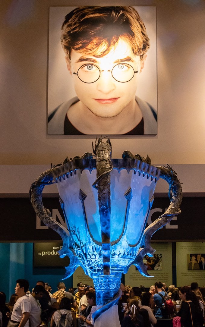 The lobby at the Harry Potter Studio Tour, London with a giant Goblet of Fire and large picture of Daniel Radcliffe as Harry Potter. 