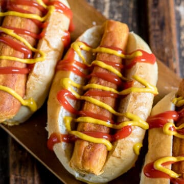 Looking down at lentil hot dogs with mustard and ketchup.