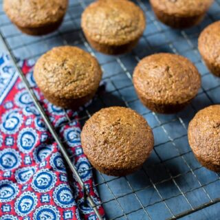 Healthy bran muffins cooling on a vintage rack on a blue background
