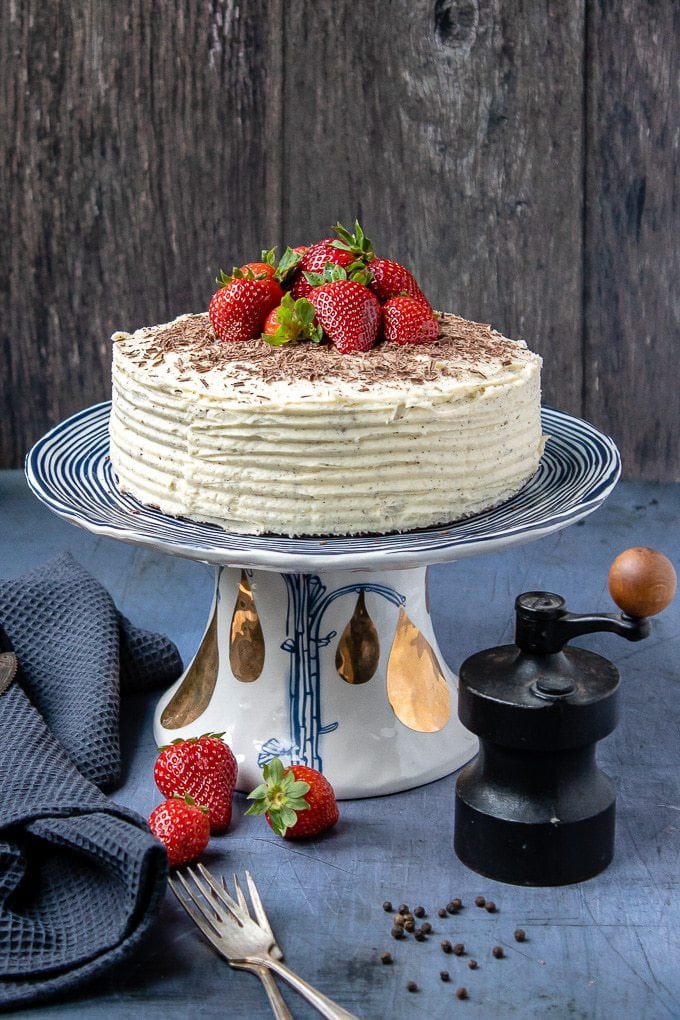 A cake with fruit on top on a wooden table.