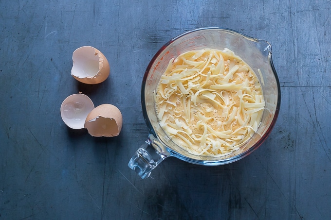 Whisked eggs and cheese in a jug.