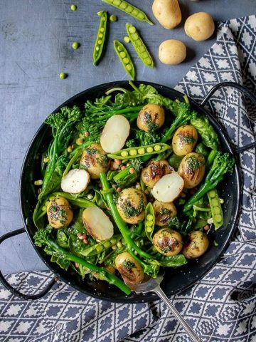 A bowl of fresh, healthy and tasty broccoli salad with peas, potatoes and herb dressing. Vegan, dairy free, gluten free.