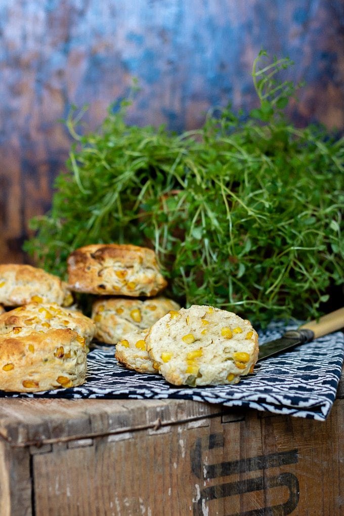 Corn and jalapeno scones with goat's cheese on a vintage crate with antique knife and pot of thyme