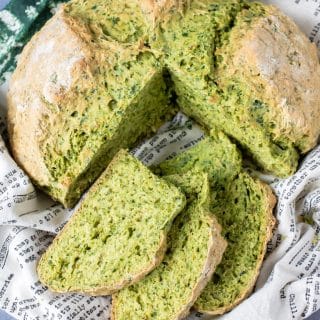 A loaf of kale herb soda bread recipe with slices cut out