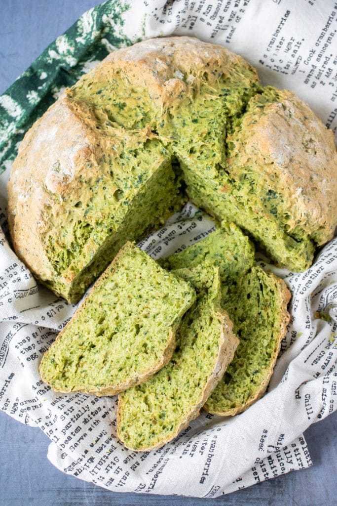 A loaf of kale herb soda bread recipe with slices cut out