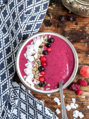 Bowl of smoothie with berries, seeds and coconut.