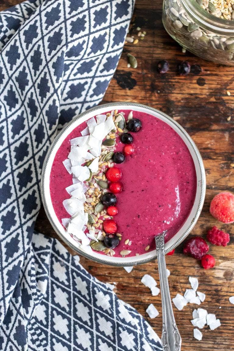Bowl of smoothie with berries, seeds and coconut.