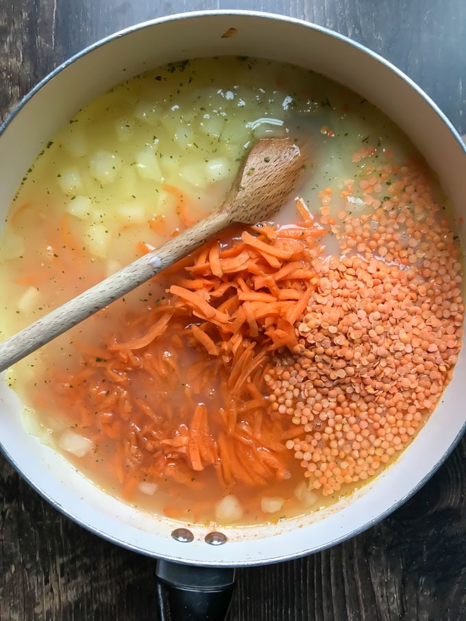Stock, carrots and lentils added to the pan.