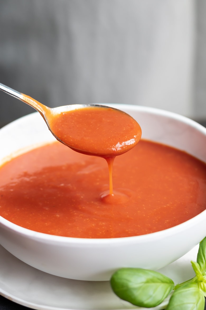 Spoon dripping into a bowl of easy homemade tomato soup recipe.
