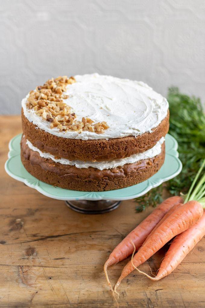 A vegan carrot cake on a cake stand.