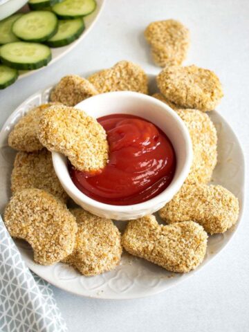Baked vegan chicken nuggets (an easy 6 ingredient, 30 minute, soy free recipe). A plate of chickpea nuggets with a bowl of ketchup.
