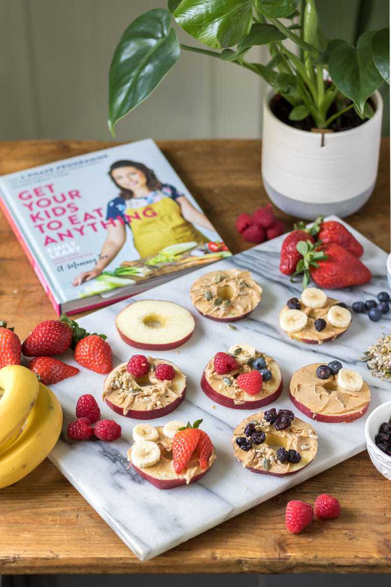 A tray of apple pizzas, slices of apple with peanut butter, fruit and seeds. An easy health snack idea for kids. Get the recipe. 