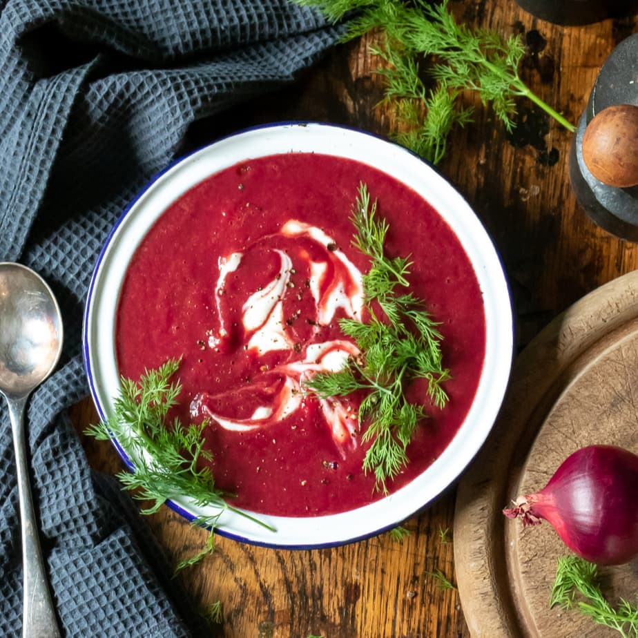 Bowl of beet soup with dill.