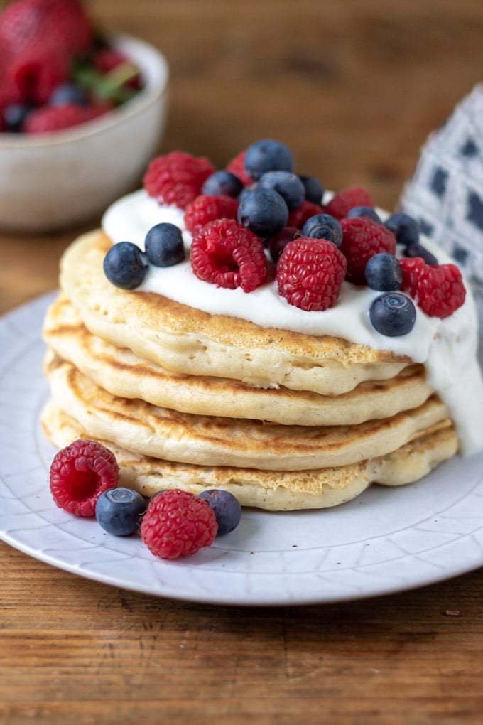 A stack of easy vegan pancakes with coconut yogurt and fresh berries