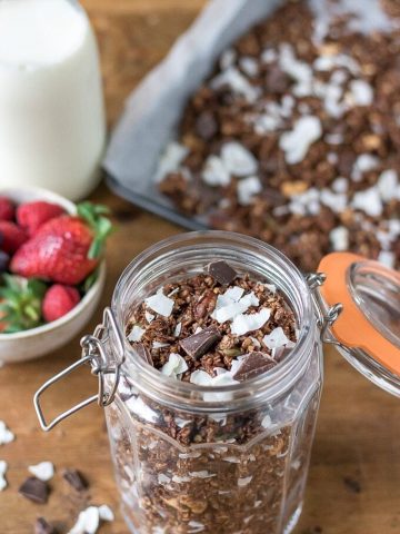Looking down into a jar of homemade granola with chocolate and coconut. A healthy vegan breakfast.