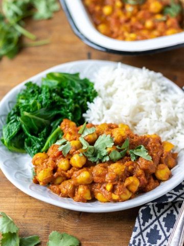 A plate of delicious vegan chickpea curry, shown with rice and steamed kale. 20 minute recipe.