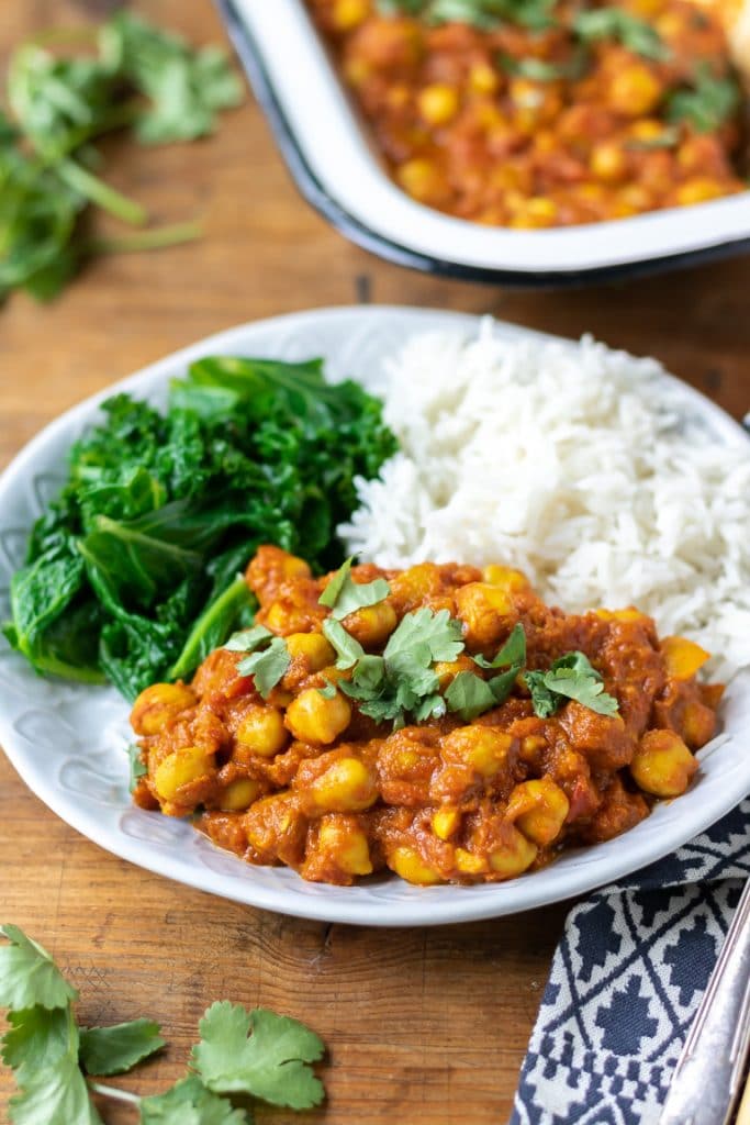 Plate of chickpea curry with rice and steamed kale.