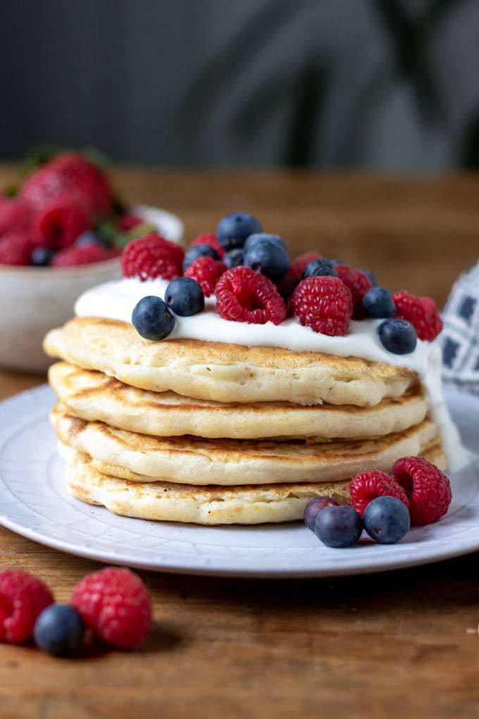 A stack of pancakes with yogurt and fresh berries. 