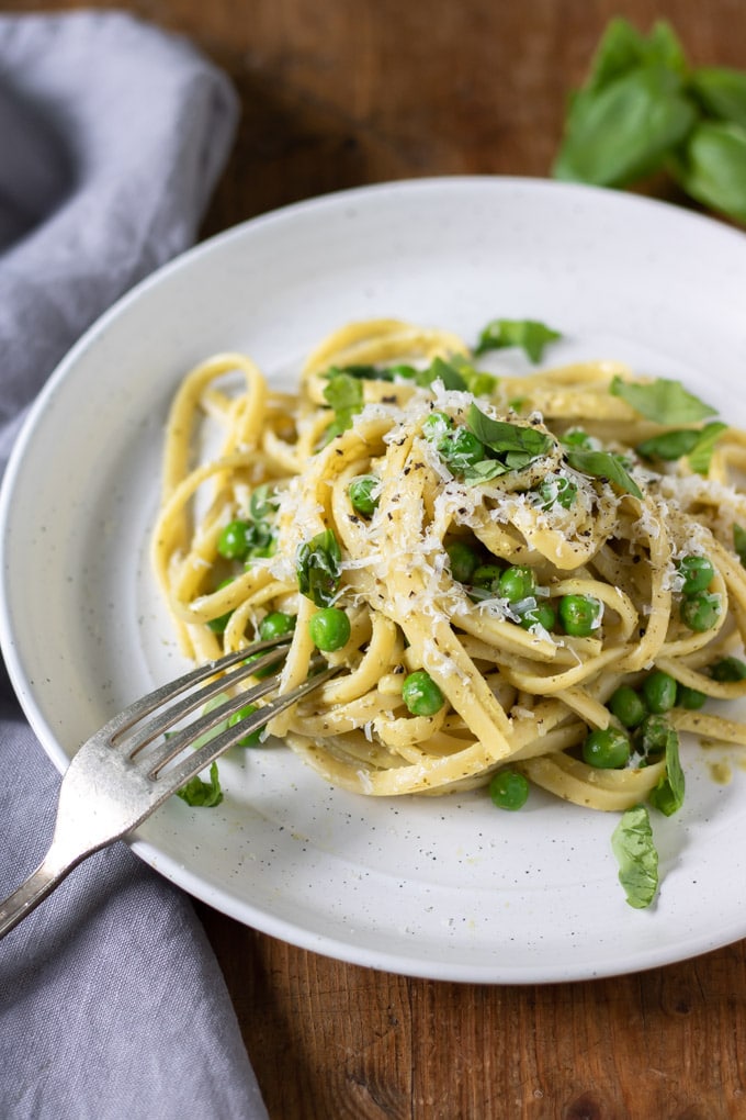 A plate of pasta with a fork taking a bite.