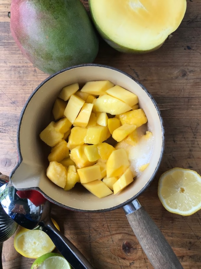 Pot di pezzi di mango e zucchero.