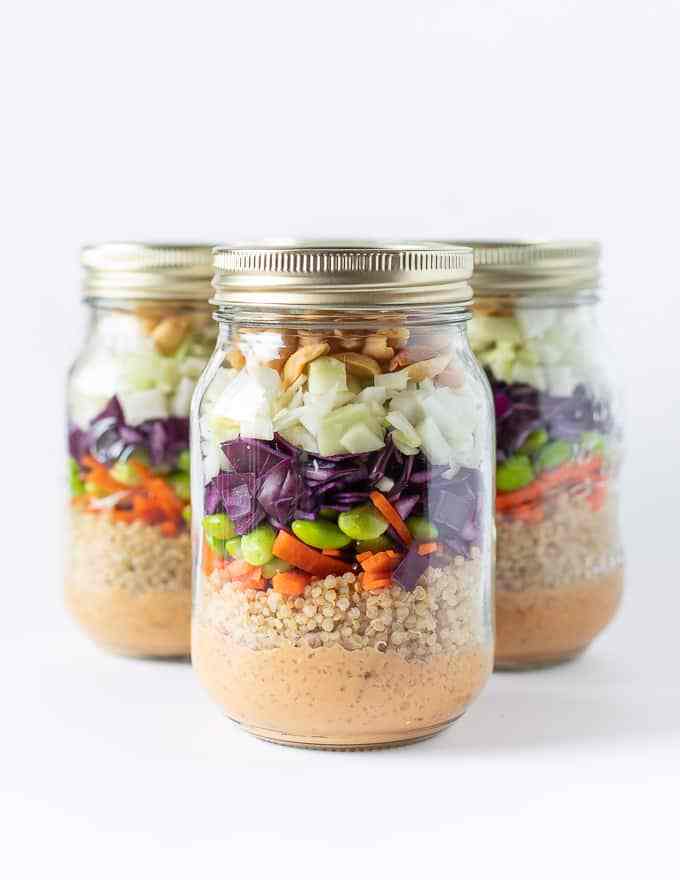 Three jars full of crunchy peanut salad with quinoa