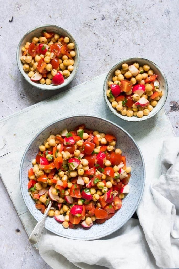 A bowl of chickpeas salad made in the instant pot with a serving bowl of it in front.