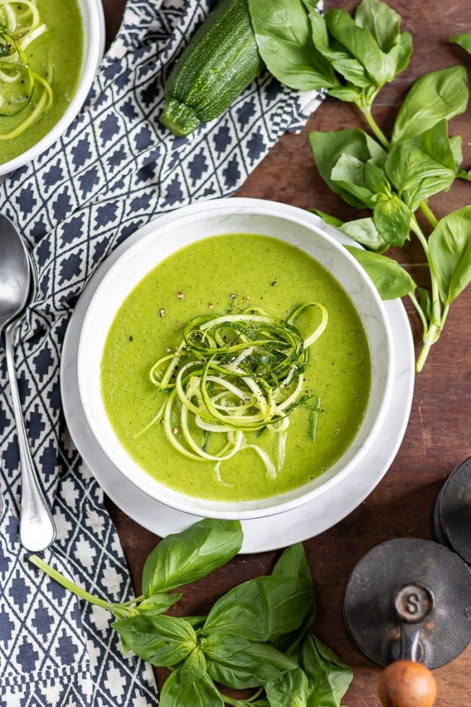 Bowl of soup next to fresh basil.