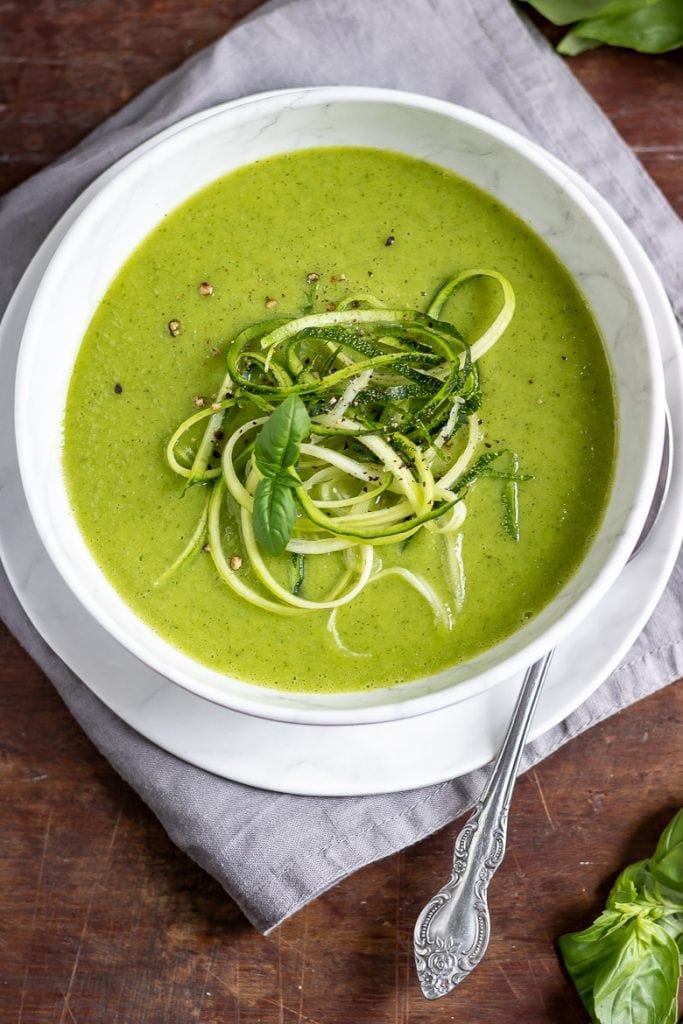 Bowl of zucchini soup with spiralized zucchini topping it.