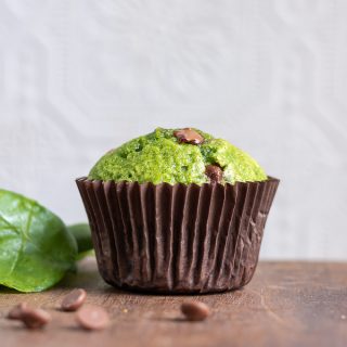 Side view of a sweet Spinach Muffin recipe with chocolate chips, with some chocolate in front