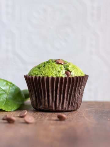Side view of a sweet Spinach Muffin recipe with chocolate chips, with some chocolate in front