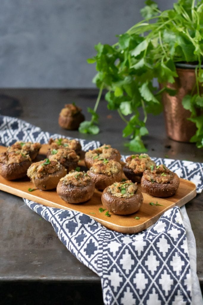A table with a tray of herb and garlic stuffed mushroom appetizers (vegetarian, vegan and can be gluten free)