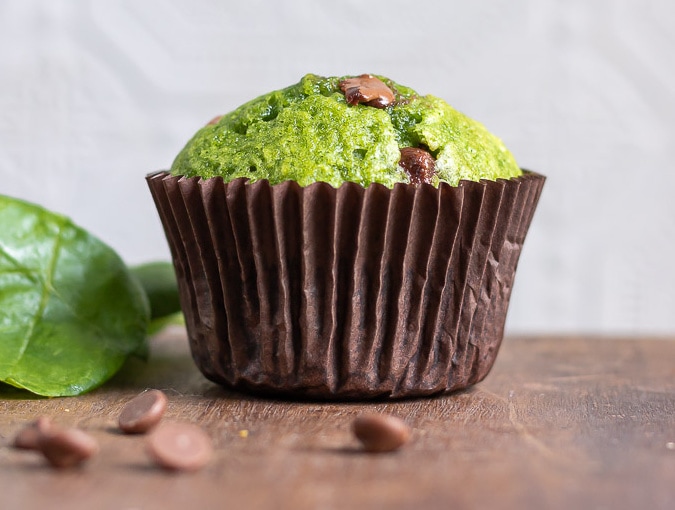A green sweet spinach muffin with chocolate chips.