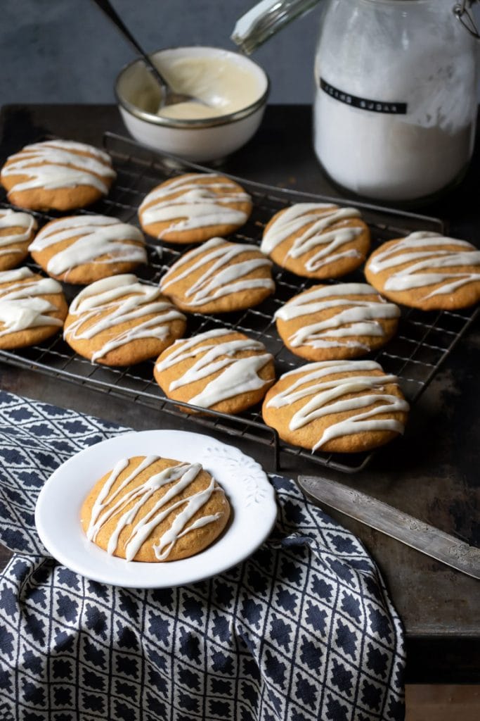 Iced pumpkin cookies on a cooling rack.