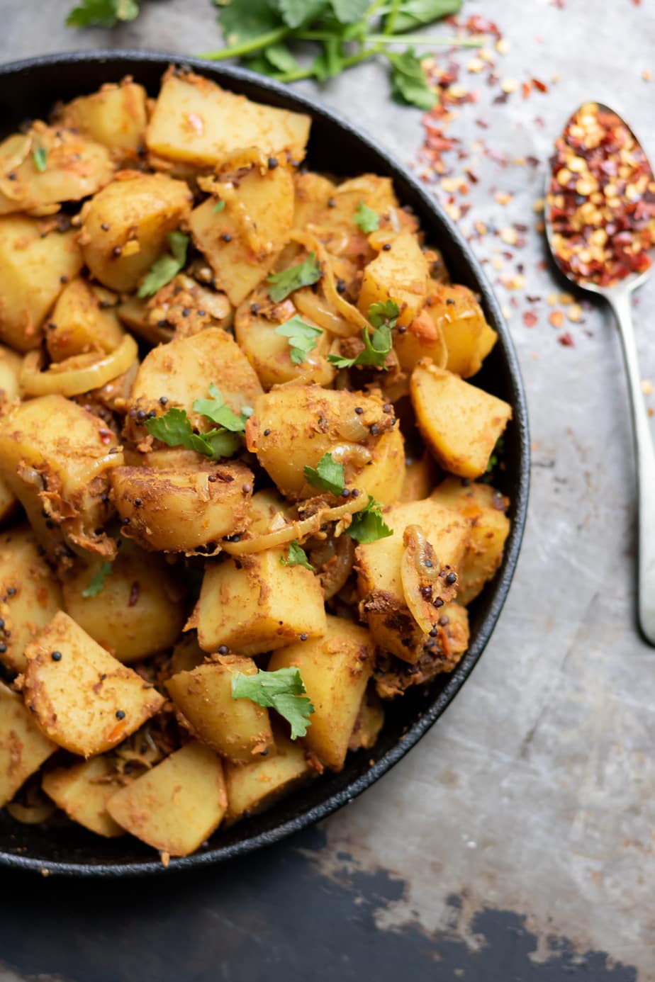 Close up of a dish of Bombay Indian Potatoes sprinkled with fresh cilantro.