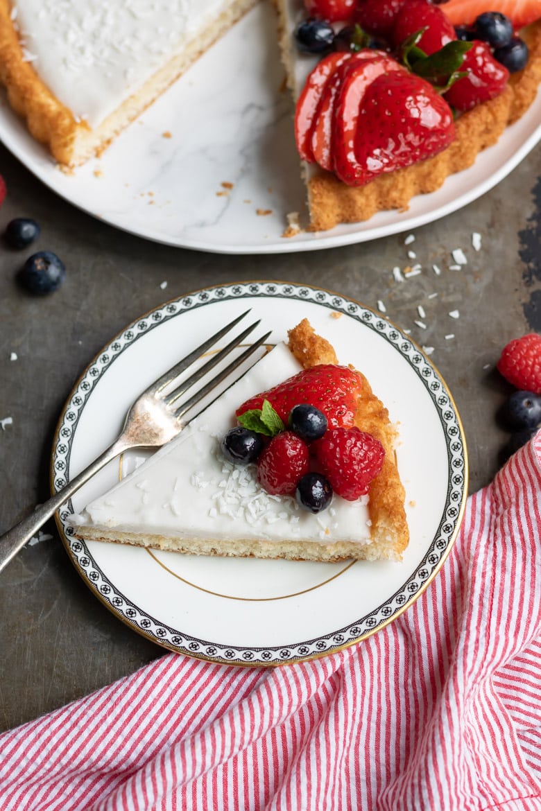 A slice of Coconut Fruit Flan with sponge flan case and berries.