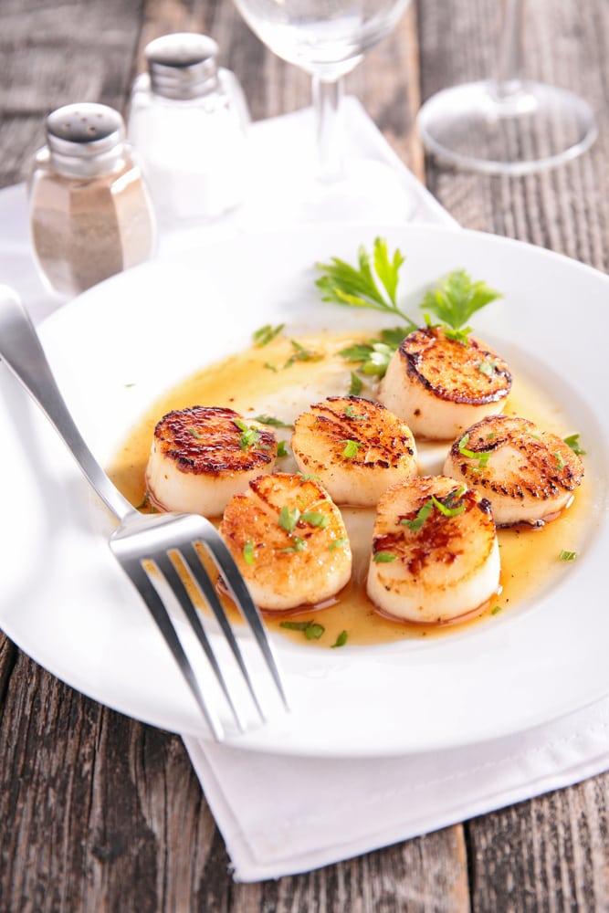 vegan scallops (vegan seafood) on a plate on a wooden outdoor table