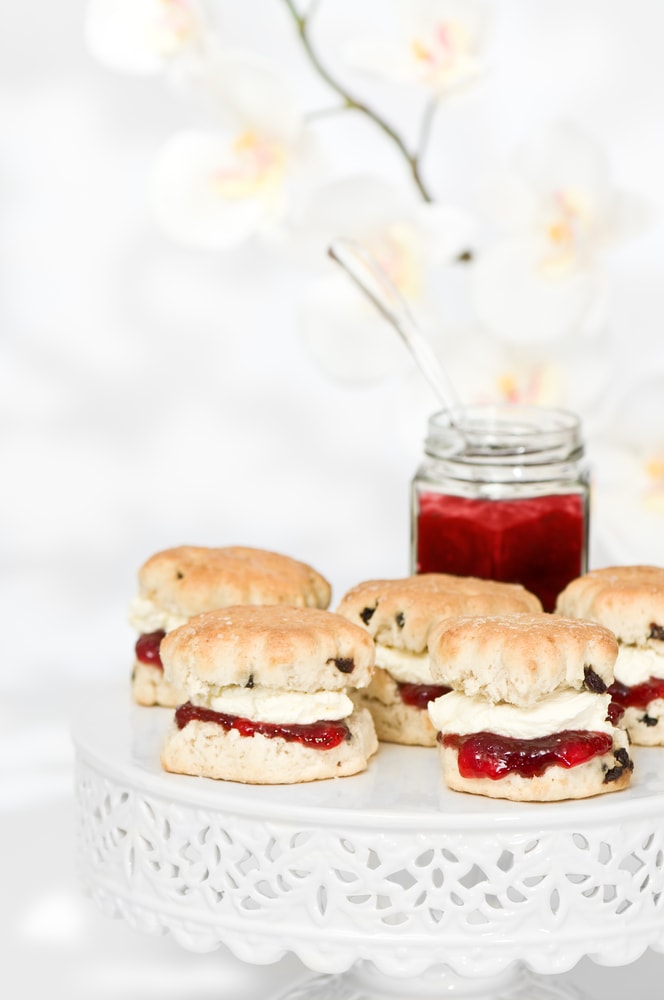 Vegan scones on a cake stand with cream and jam.