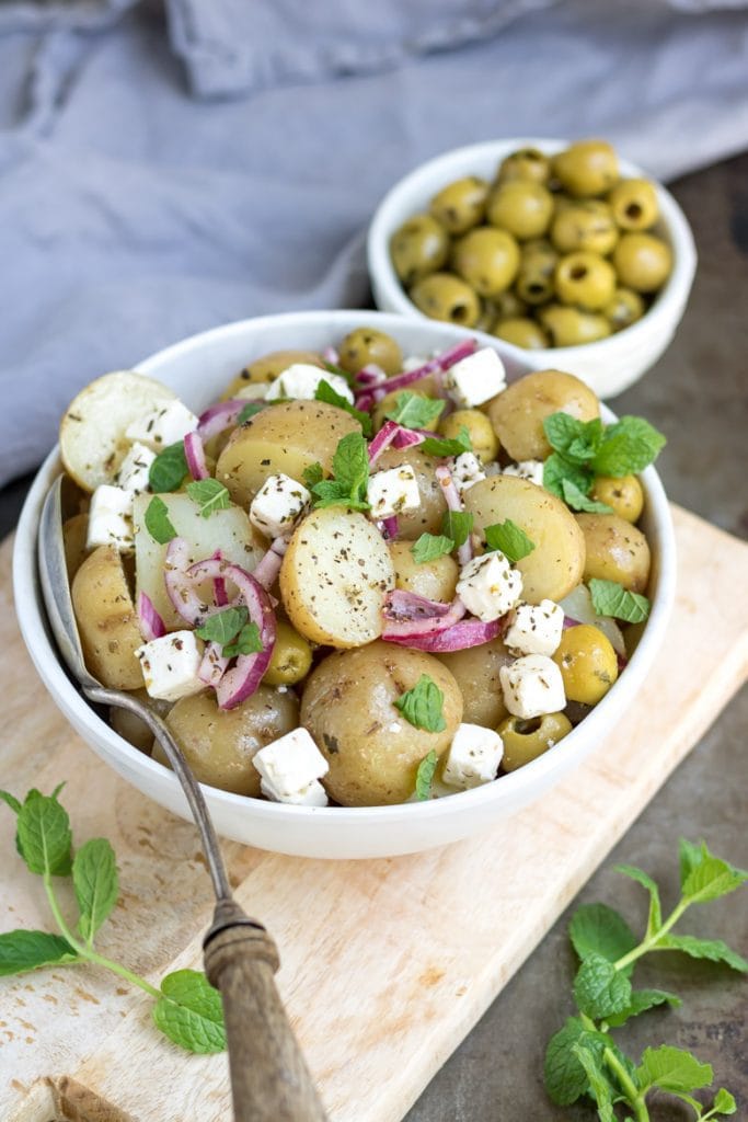 Bowl of Greek potato salad with feta and olives.
