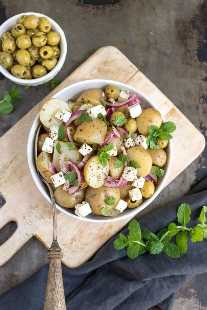 Bowl of potato salad on a wooden board