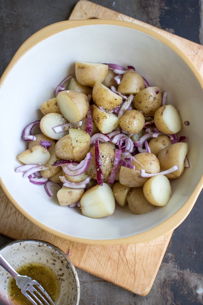 Potatoes and onions in a mixing bowl.
