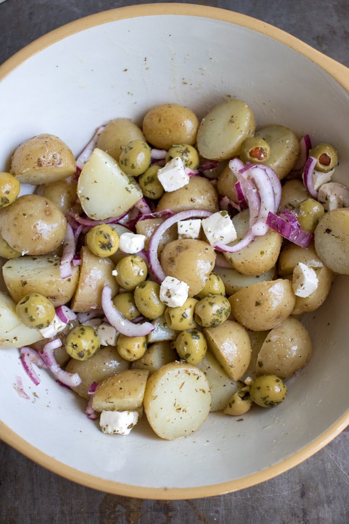 Greek potato salad in a mixing bowl.