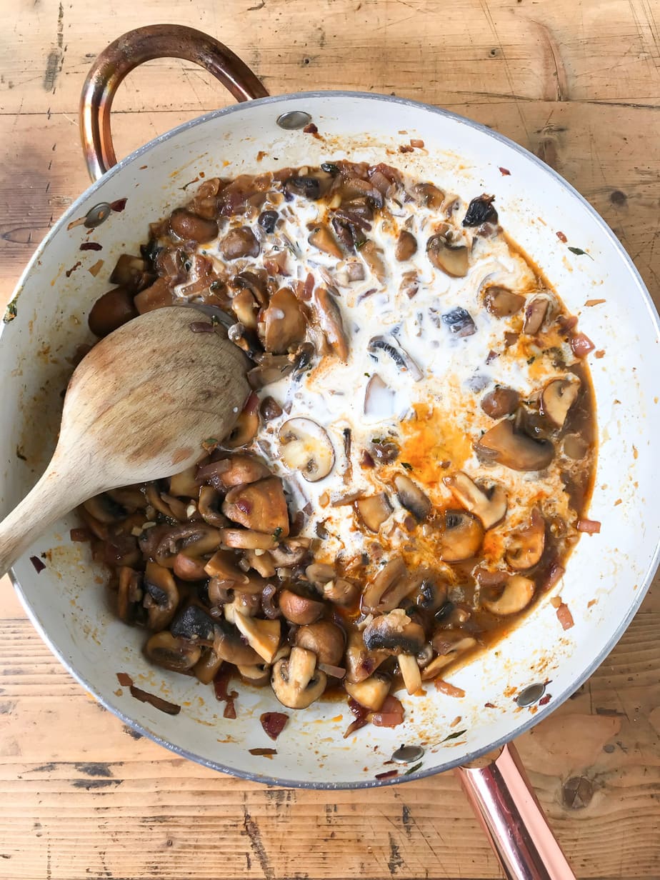 Pan of cooked mushrooms and cream. 