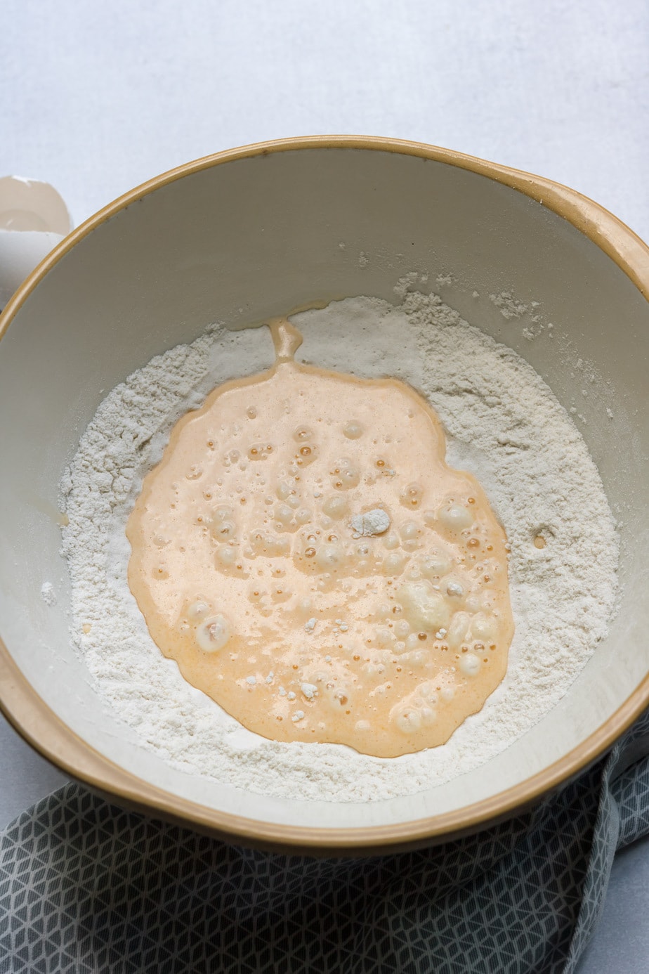 Mixing bowl of flour and whisked eggs.