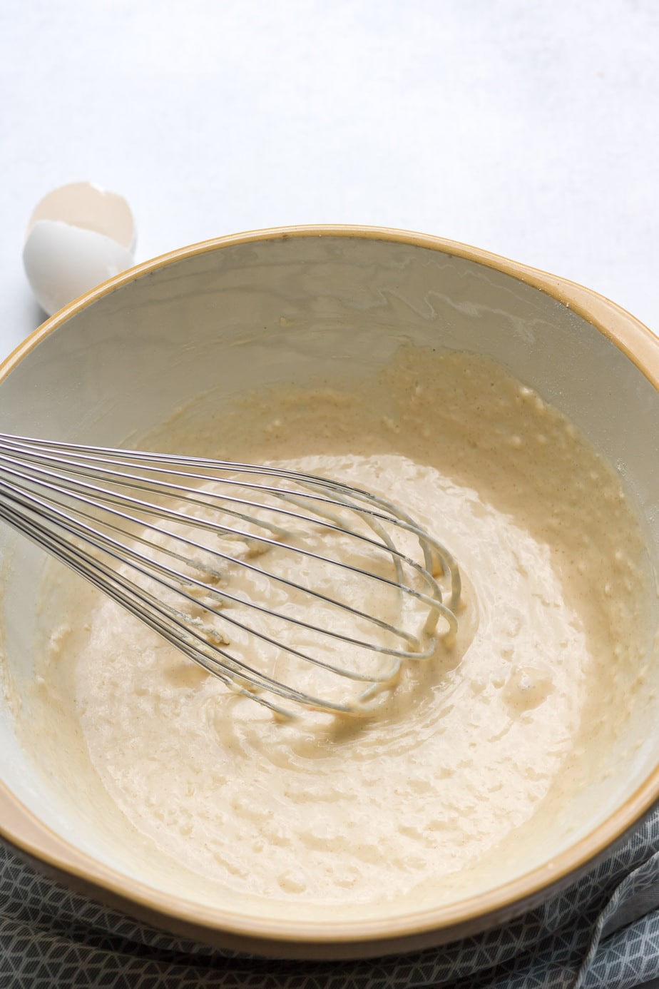 Bowl of pancake batter with whisk.