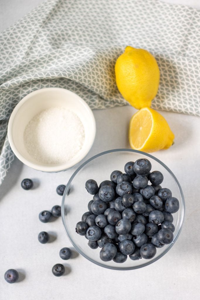 Blueberries, lemons and sugar on a table.
